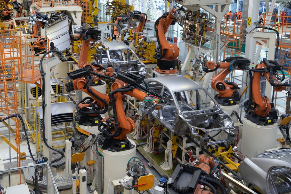 An automotive production line with robots arms building cars