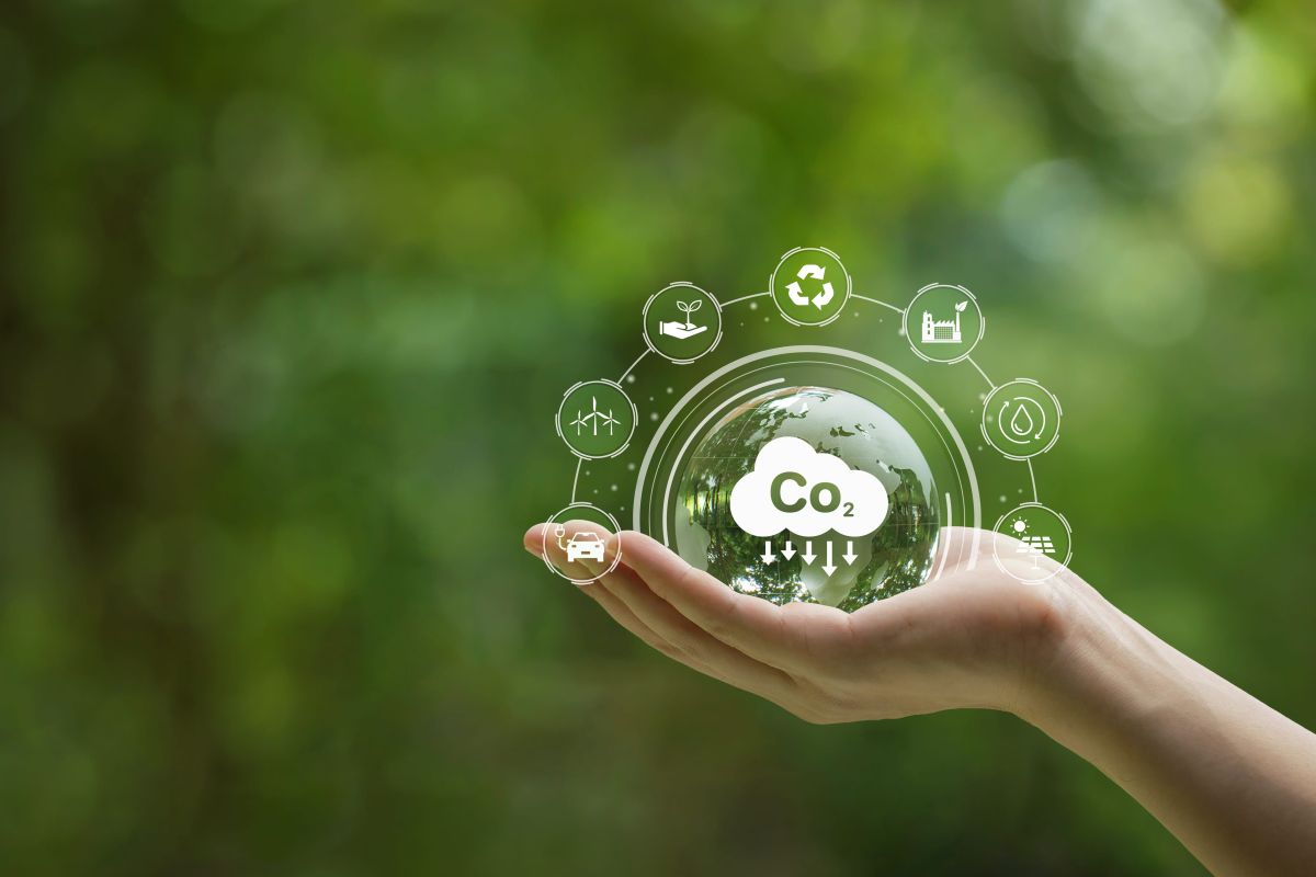 A hand holding a crystal globe with a CO2 icon.