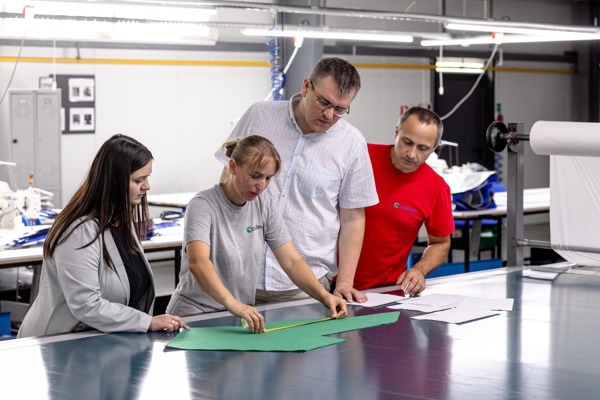 4 people measuring a piece of textile in a production center of conTeyor