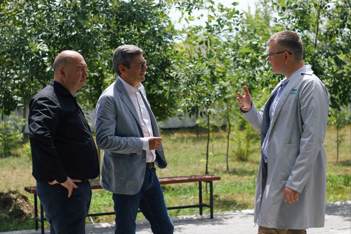 conTeyor&#039;s CEO Orm, talking with two other people in a garden